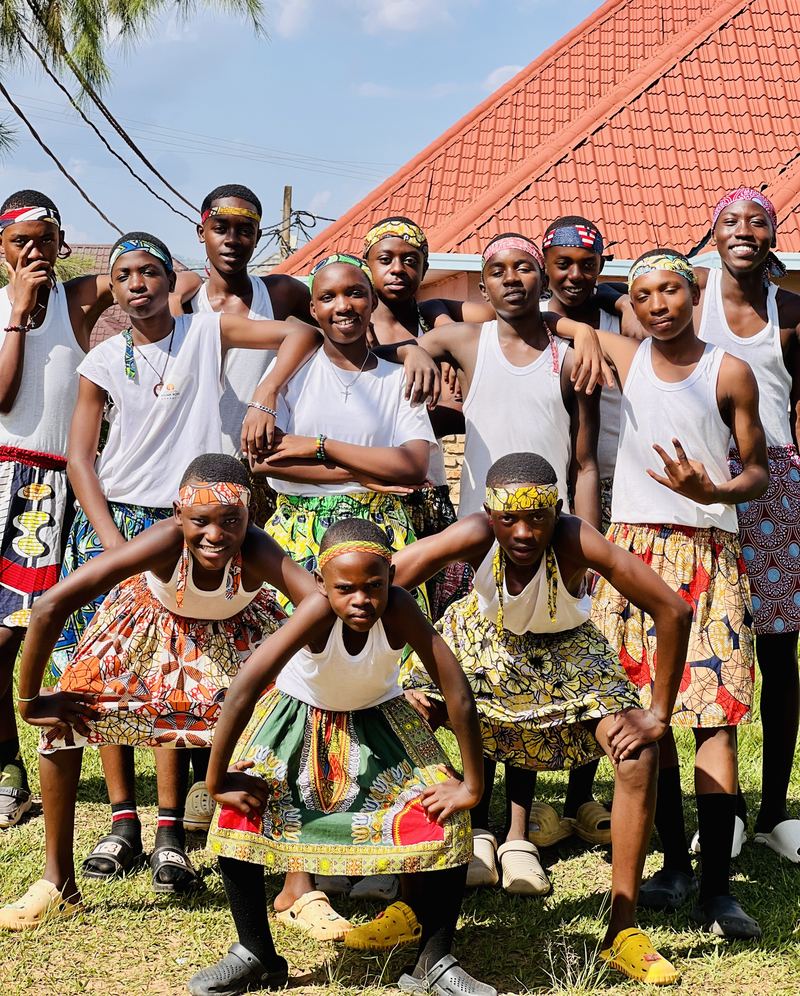 The crew striking playful poses in white vests and African Celtic Kilts.