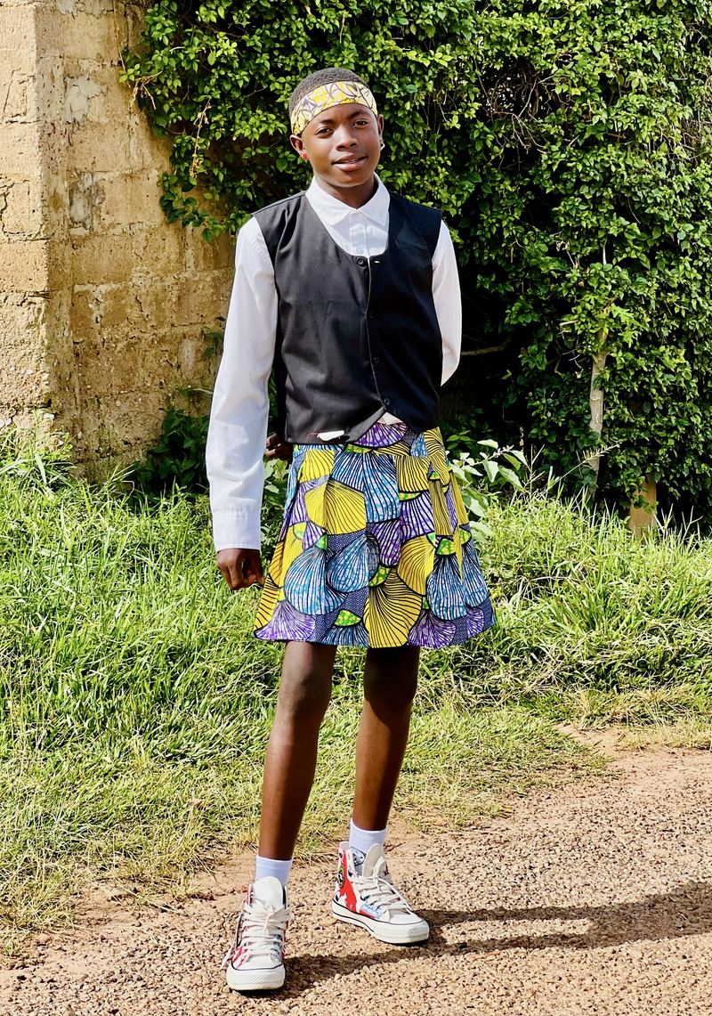 A dancer in black vest and purple-print kilt.